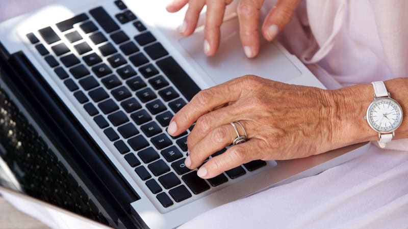 A woman's hands, typing on an Apple laptop. Image by Mimagephotography. Used with article 'For readers of Ask Amy"