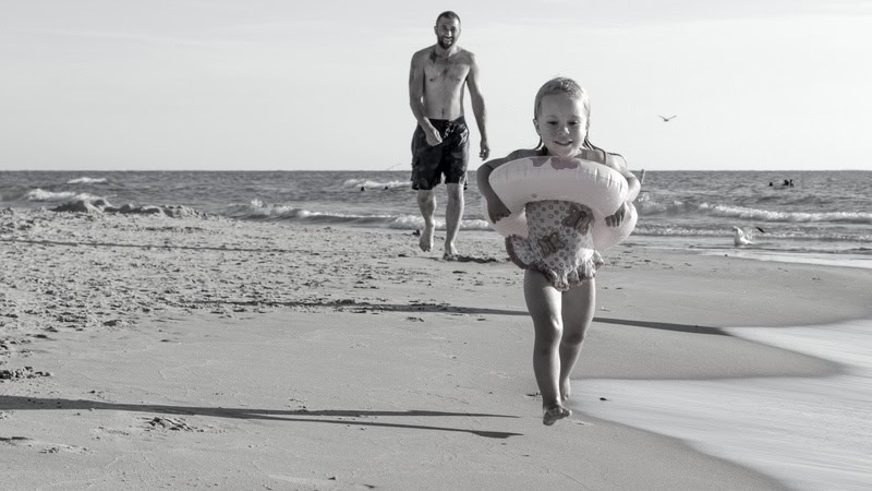 The Myrtle Beach of My Girlhood. A little girl running on the beach with her father following. Image by Susan Sheldon