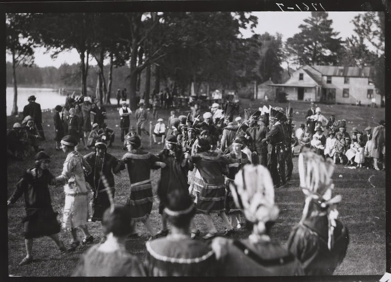 Participants dance during a 1928 gathering of five Virginia Indian tribes on the grounds of a house knownas Windsor Shades on the Pamunkey River in King William County. This image is included in the exhibition