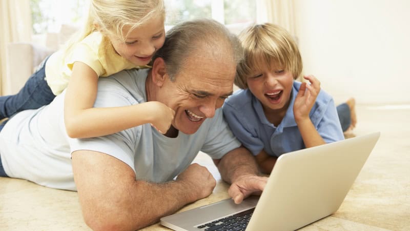 Granddad and two grandkids having fun on a laptop computer. Perhaps doing puzzles like the Jumble Puzzles: Who Needs a Doc?