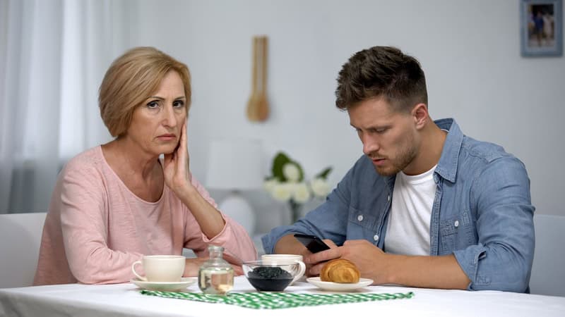 A mother is miffed at her adult son, who's looking at his phone instead of at her. Used with Asking Eric column on when a son's affair angers mom. Image by Motortion