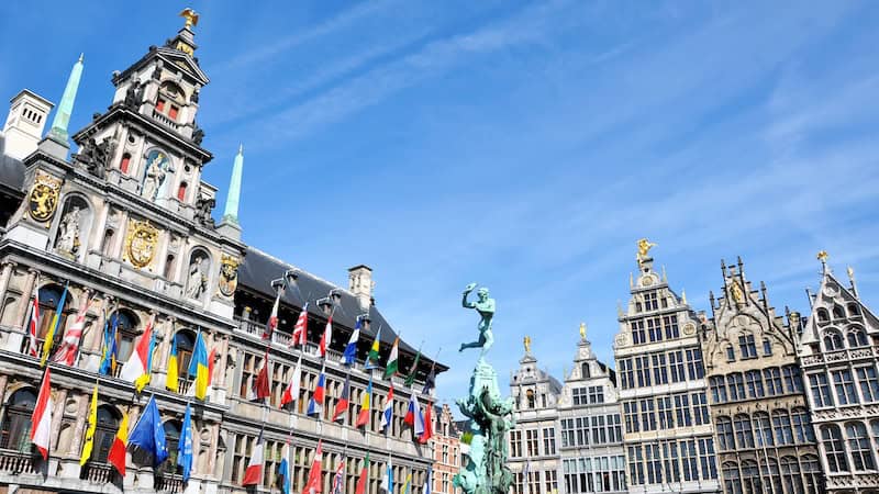 Fronting the main square in Antwerp are its City Hall, adorned with gold coats of arms, and guild houses, each topped with a golden statue. (Cameron Hewitt, Rick Steves Europe)