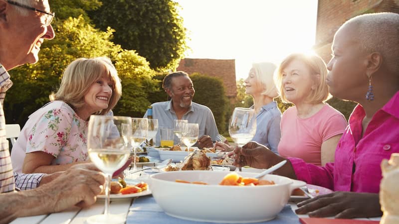 A group of older adult friends at a dinner party, by Monkey Business Images. Asking Eric: Is social media FOMO ageless?