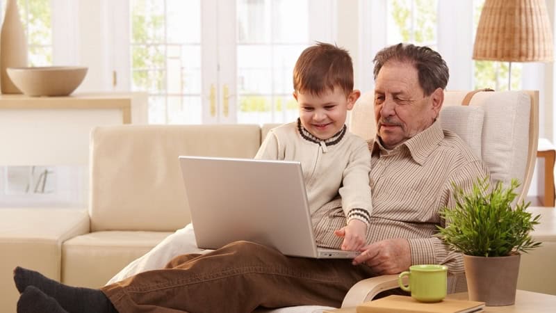 granddad and grandson on a laptop, possibly doing a puzzle like the Jumble puzzles for kids and adults