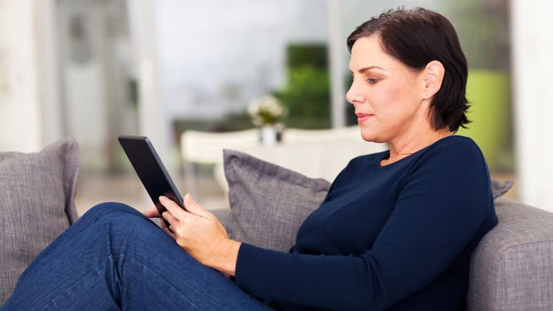 Woman on her tablet, perhaps playing a puzzle such as Boggle the musical instruments