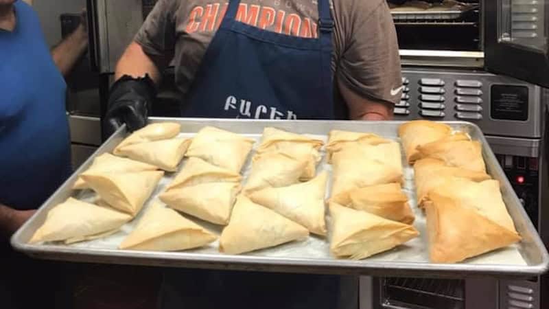 A man holding Armenian pies fresh out of the oven, for the Armenian Food Festival, in What's Booming: Fests Galore and More