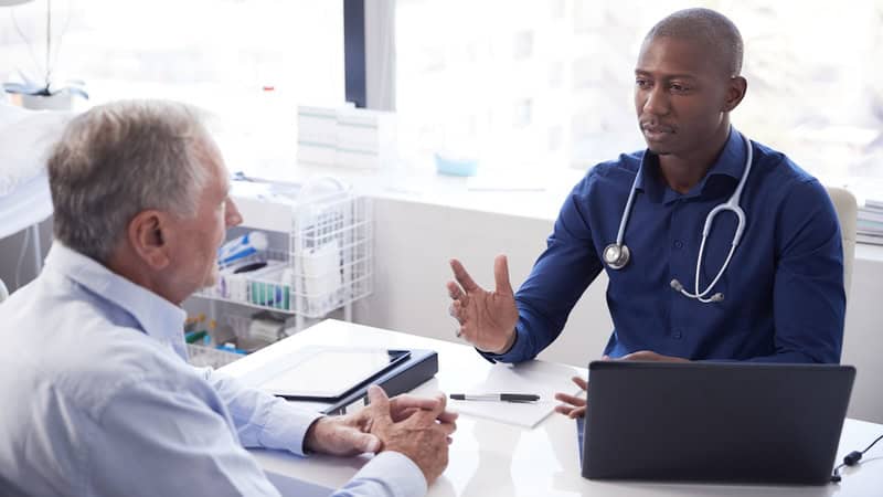 Patient with the doctor receiving diagnosis and guidance for Graves' disease. Image by Monkey Business Images