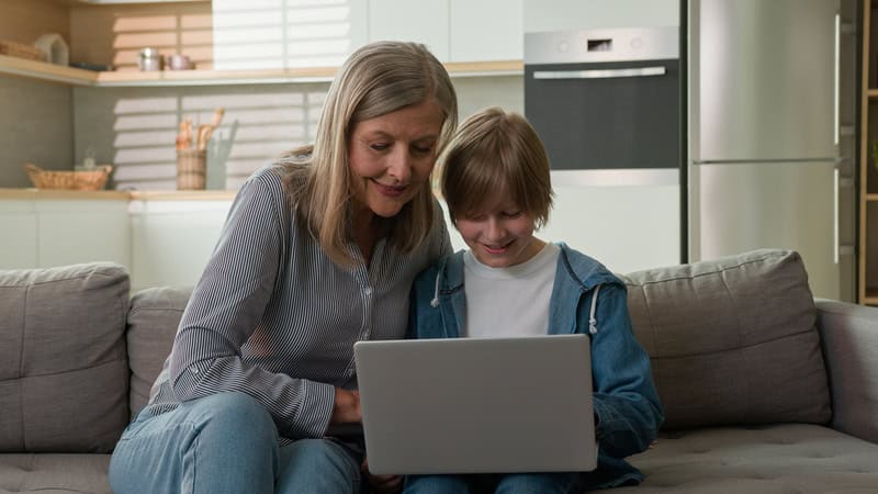 grandma and grandson on a laptop at home.