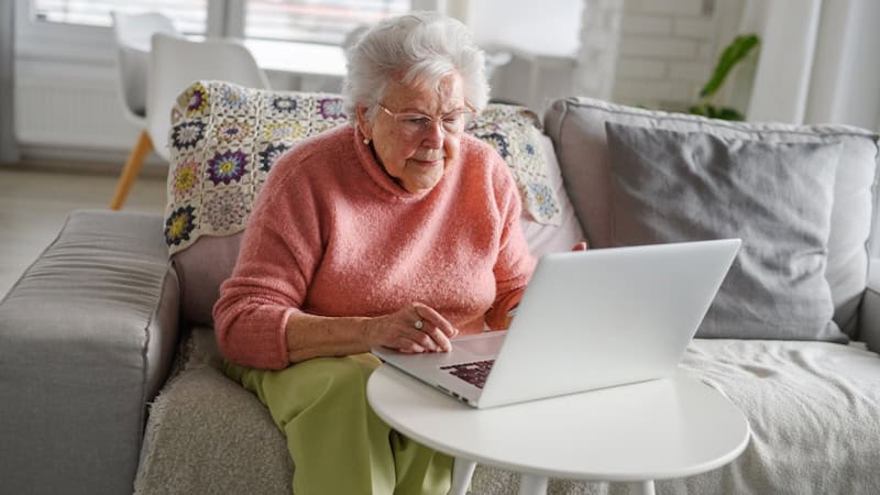 A woman on her laptop at home, possibly doing a puzzle like the Boggle country seek