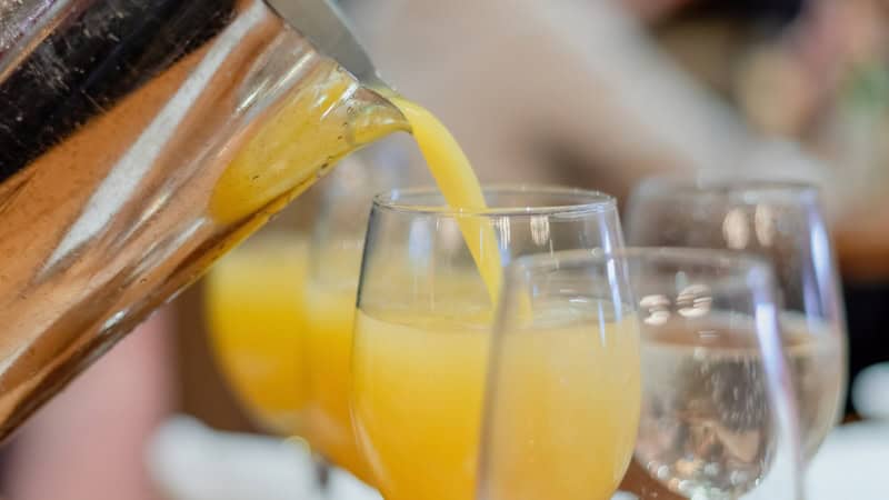 Pouring orange juice to make mimosas. By Kristen Prahl. Representing one of the common practices to avoid as you age.