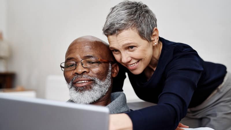 Mature man and woman looking at a computer screen, perhaps even playing Boggle the Water Mammals