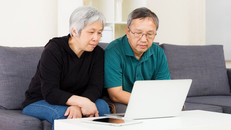 woman and man looking at laptop, perhaps doing a puzzle or game like the Boggle element-ary edition puzzle