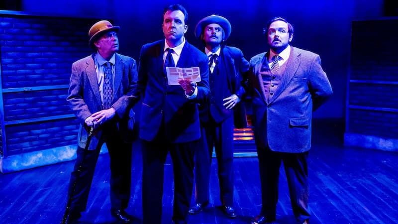 Four actors on a darkly lit stage, in Ken Ludwig's Baskerville: A Sherlock Holmes Mystery, at Virginia Repertory Theatre in 2023. Used for What's Booming: Fan House Cheer