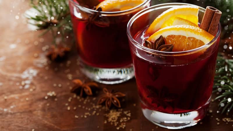 German mulled wine in two glasses, surrounded by holiday decorations. By Julia Sudnitskaya