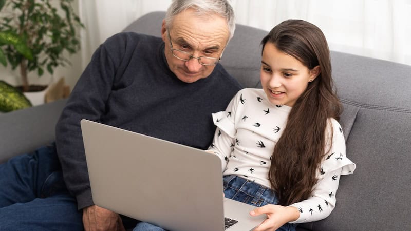 A granddad and granddaughter on a laptop. Image by Andrew Angelov. Used with Jumble puzzles with Apollo 11 riddle, Dec. 23 2024