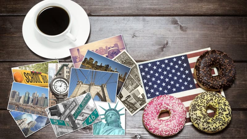 For Christmas donuts and word peace: a set up of coffee cup, New York City pictures, a small U.S.A. flag, and donuts.