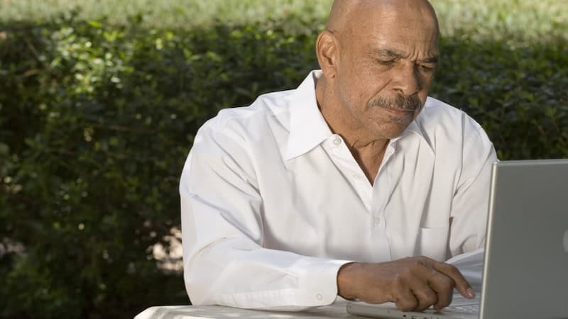 A man on a computer, perhaps playing a game like Boggle the land formations