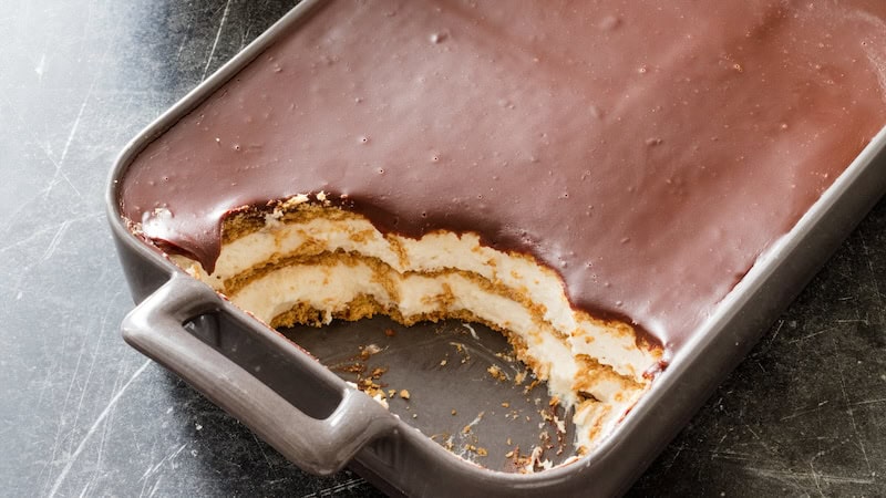 Top view of a chocolate eclair cake with several servings cut away.