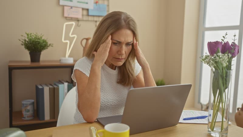 A woman is concerned about her finances as she stares at her computer at home. She needs CFPB alternatives to help her now.