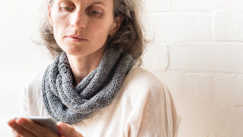 sad woman on her smartphone, perhaps engaging in parasocial relationships. Image by Natalie Board