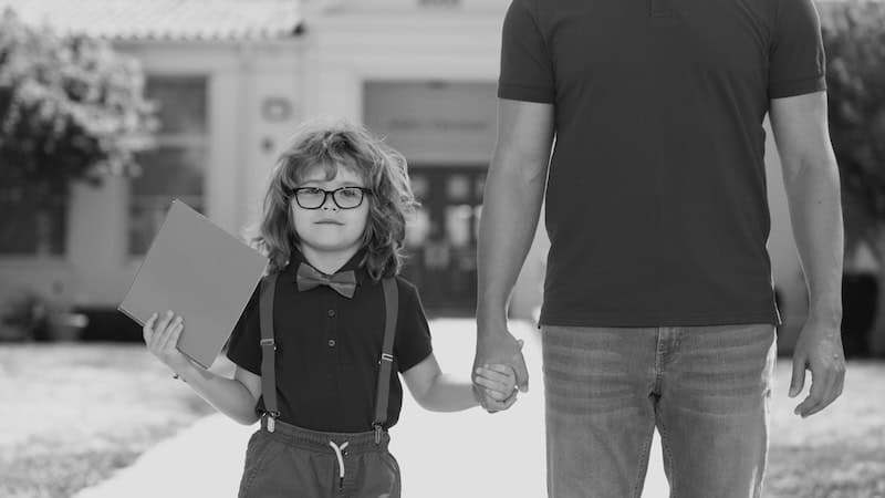 A young student walks out of school holding her dad's hand. By Volodymyr Tverdokhlib. Essay on a man preparing for the father-of-the-bride toast and remembering his daughter's first parent-teacher conference